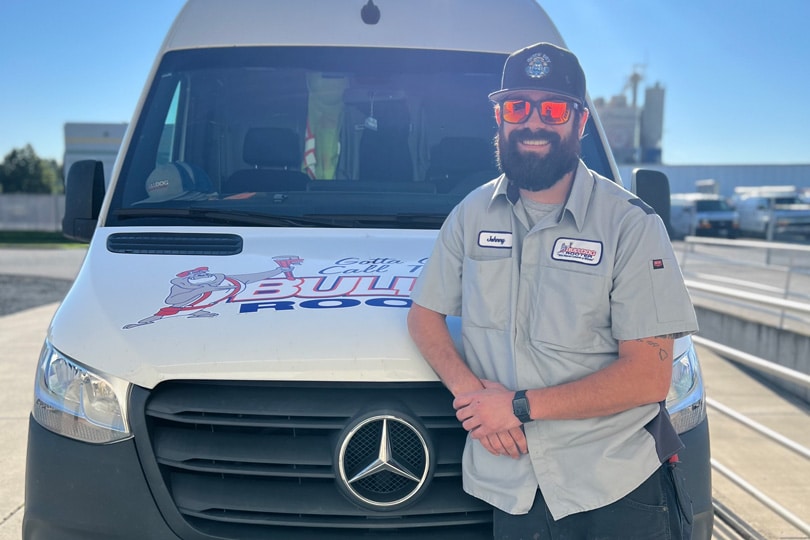 A Bulldog Rooter technician standing in front of his work truck