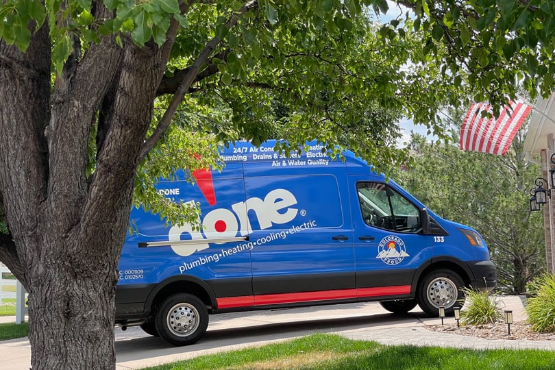 A Done Plumbing service van parked on a residential street